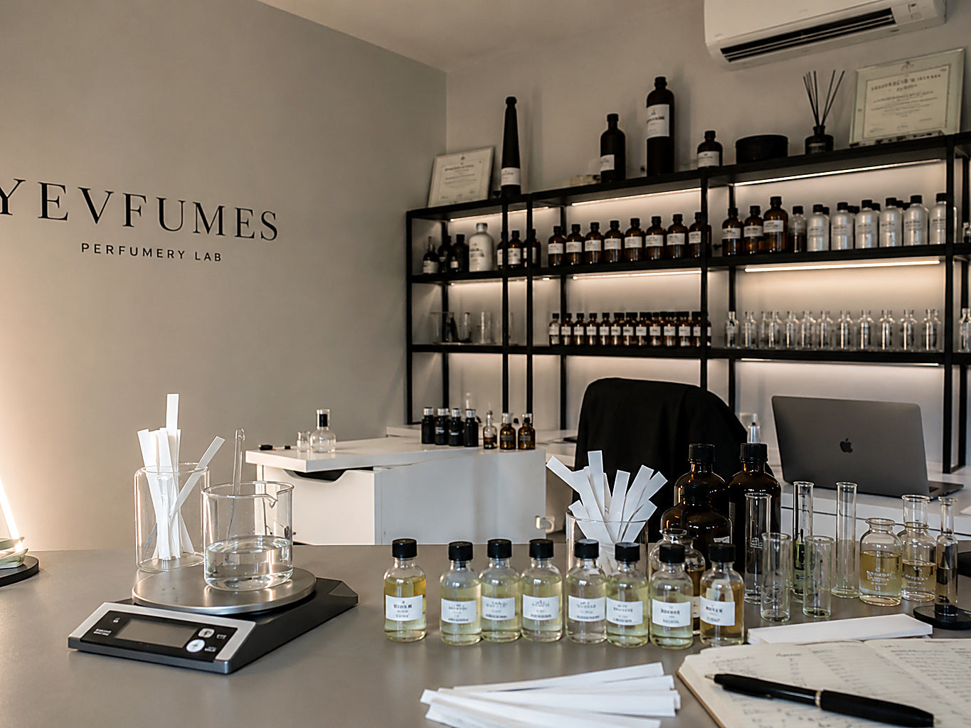 Shelves of raw perfumery materials in amber and clear glass bottles at the Yevfumes studio